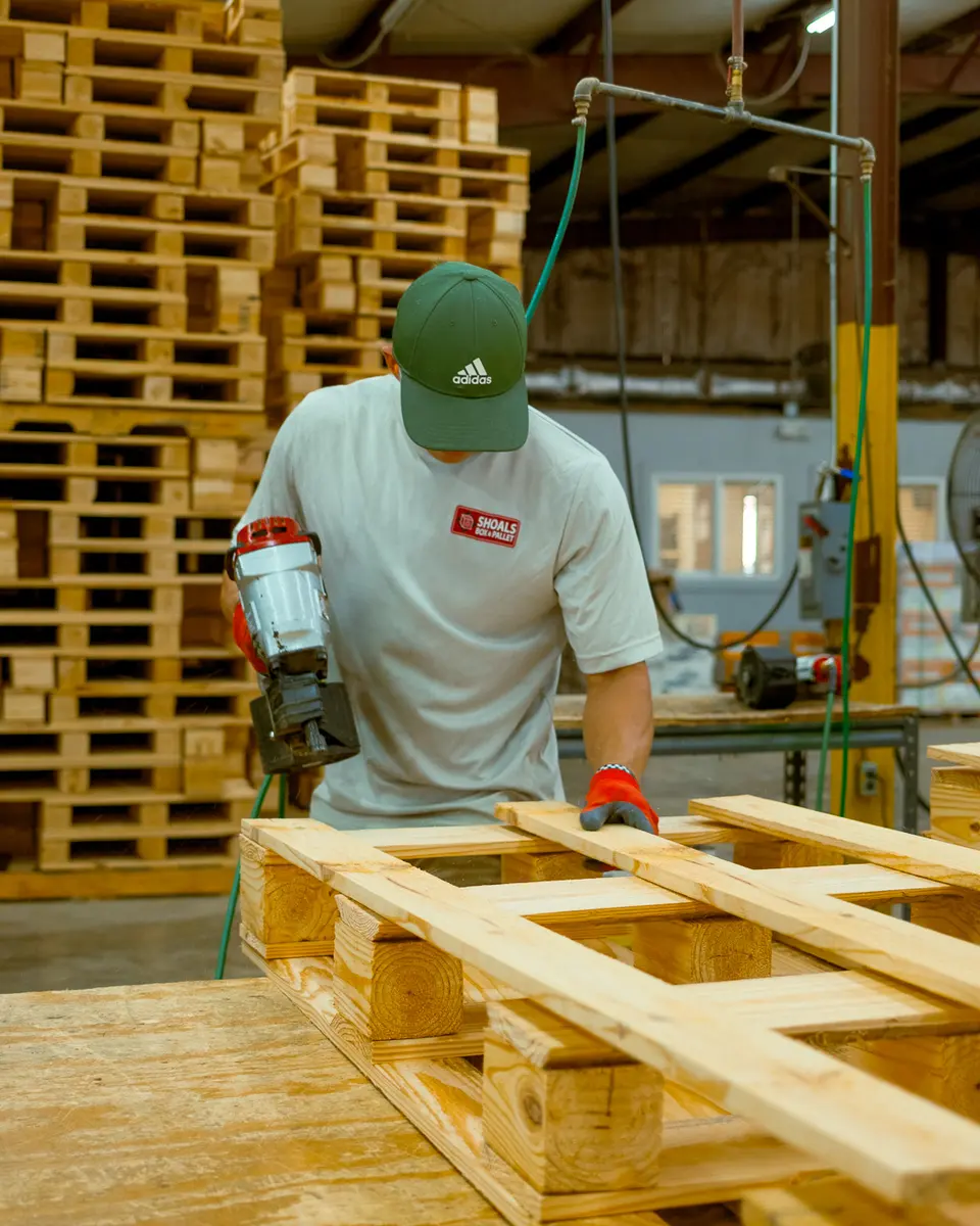 Pallet builder assembling a custom deck on the Florence shop floor