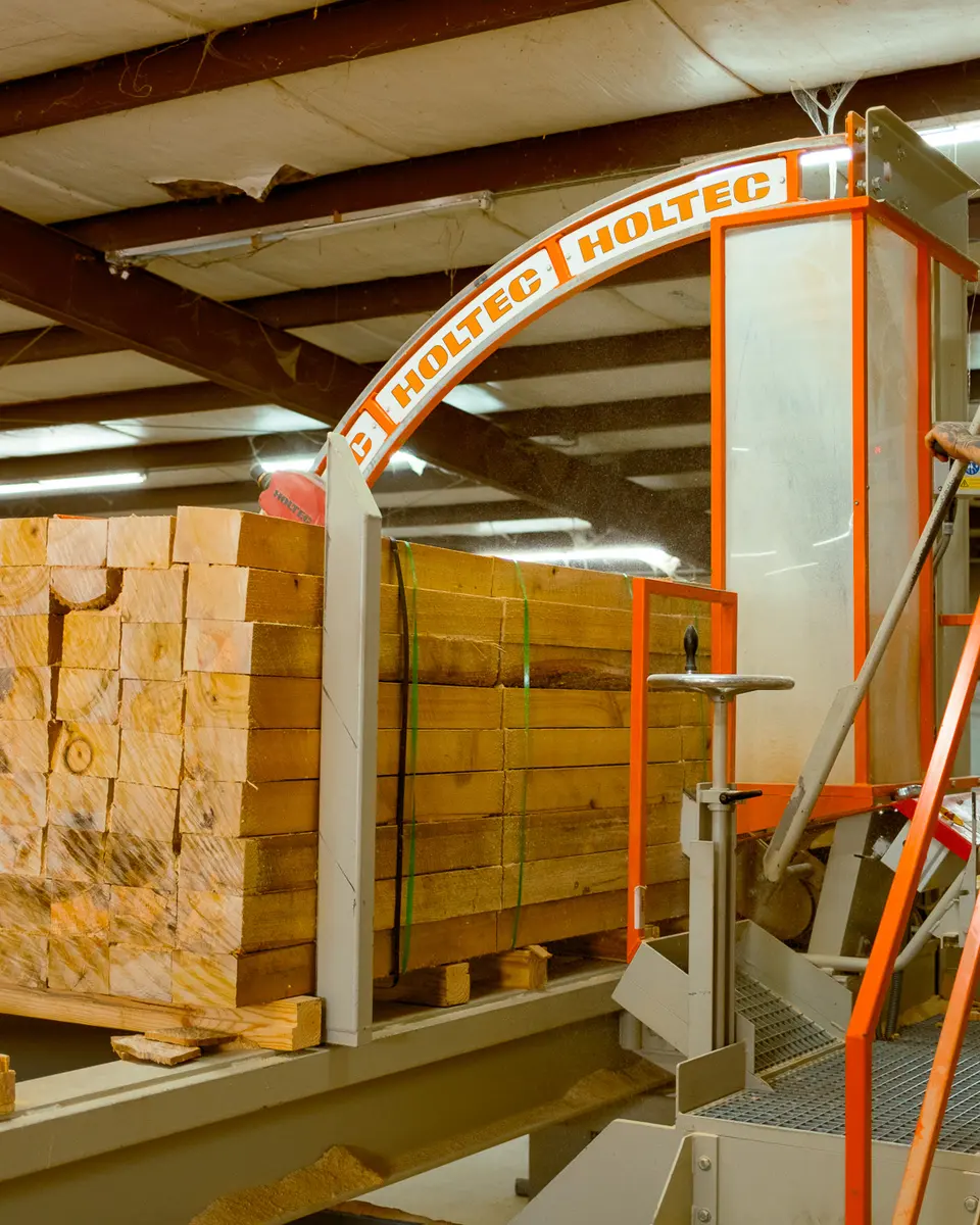 Operator running cut stock through the saw line
